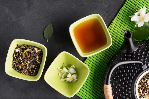 Assortment of dry tea herb on black slate backdrop
