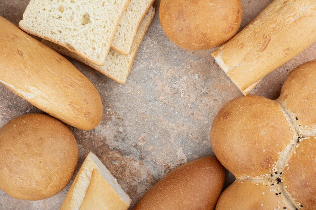 Assortment of fresh bread on marble background