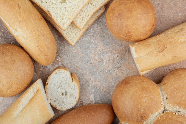 Assortment of fresh bread on marble background