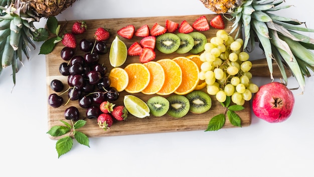 Foto gratuita assortimento di frutta sul tagliere su sfondo bianco