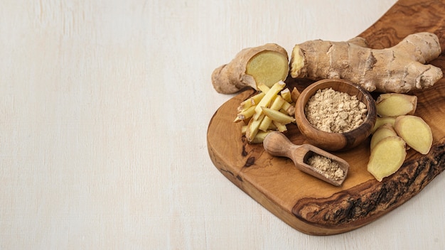 Assortment of ginger on wooden board with copy space