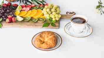 Foto gratuita assortimento di frutta sana con pane e tazza di tè su sfondo bianco