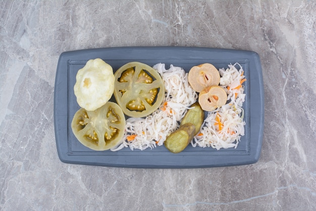 Free photo assortment of homemade pickles on dark plate.