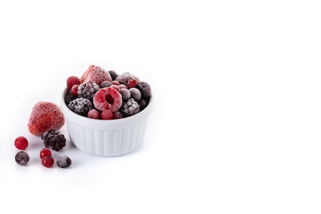 Ассортимент замороженных ягод в миске на белом фоне