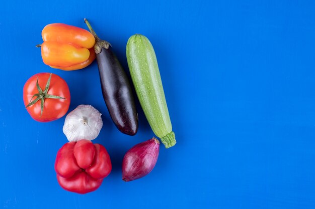 青い表面にたくさんの新鮮な熟した野菜の品揃え