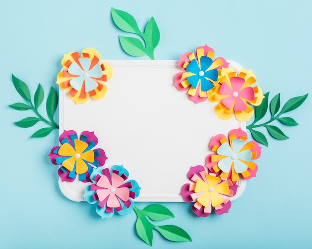 Assortment of multicolored paper spring flowers on whiteboard