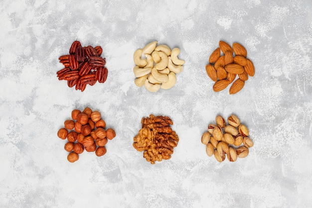 Free photo assortment of nuts cashew, hazelnuts, walnuts, pistachio, pecans, pine nuts, peanut, raisins.top view