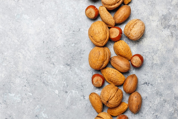 Assortment of nuts on concrete surface.Hazelnuts, walnuts, pecans, peanut,almonds,top view