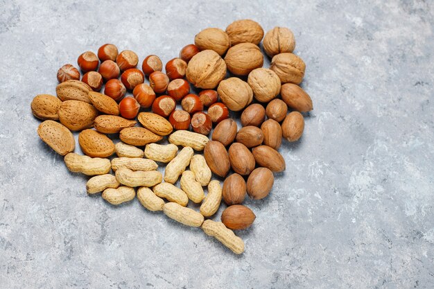 Assortment of nuts on concrete surface.Hazelnuts, walnuts, pecans, peanut,almonds,top view