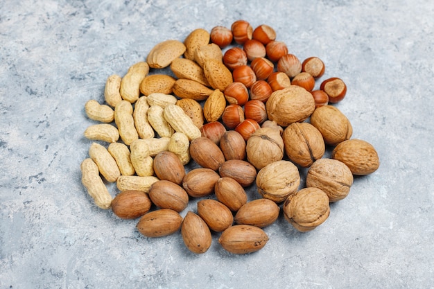 Assortment of nuts on concrete surface.Hazelnuts, walnuts, pecans, peanut,almonds,top view