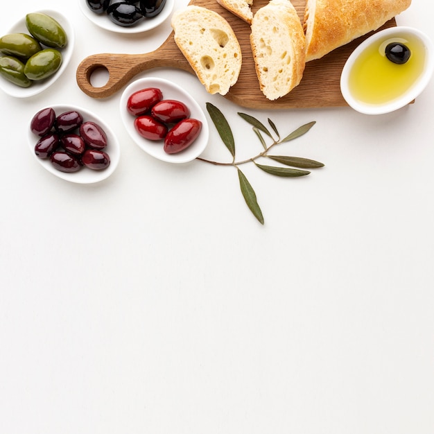 Assortment of olives bread slices and olive oil with copy space
