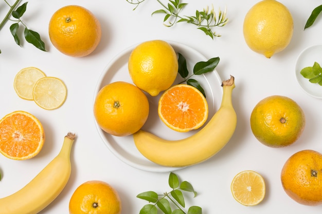 Foto gratuita assortimento di banane e arance biologiche