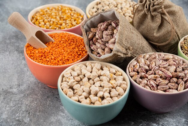 Assortment of raw dry legumes composition on marble table surface.