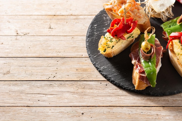 Assortment of Spanish pintxos on wooden table Typical spanish food