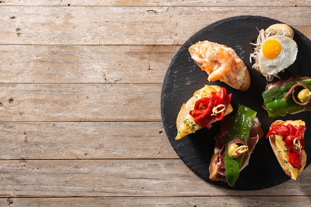 Assortment of Spanish pintxos on wooden table Typical spanish food