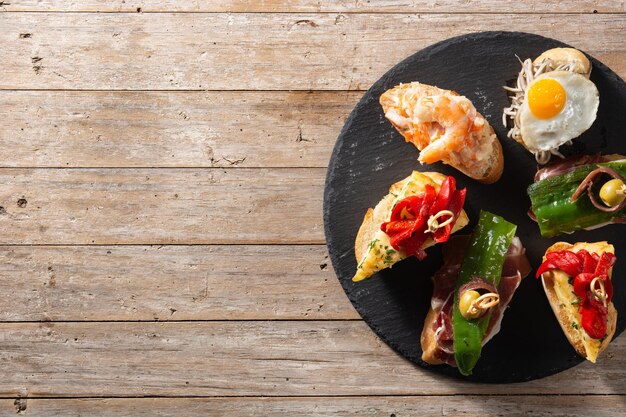 Assortment of Spanish pintxos on wooden table Typical spanish food