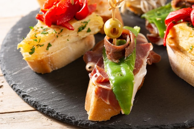 Foto gratuita assortimento di pintxos spagnoli su tavola di legno cibo tipico spagnolo