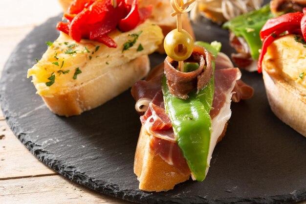 Assortment of Spanish pintxos on wooden table Typical spanish food