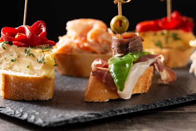 Assortment of Spanish pintxos on wooden table Typical spanish food