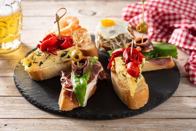 Assortment of Spanish pintxos on wooden table Typical spanish food