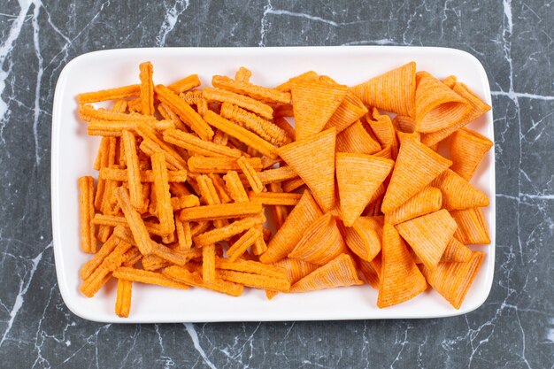 Assortment of spiced chips on white plate.