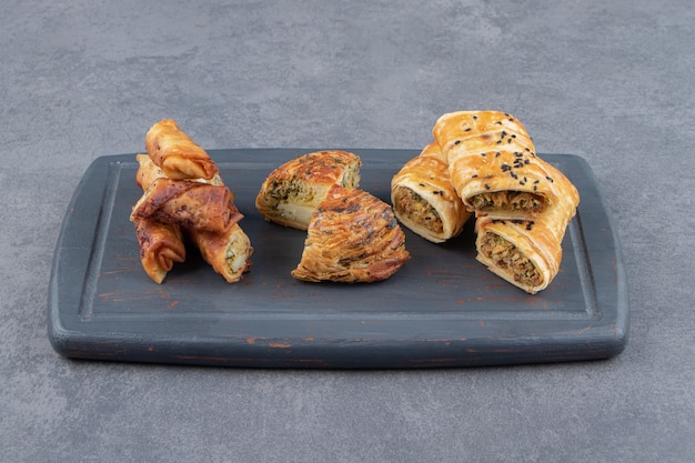 Assortment of stuffed pastries on dark board.