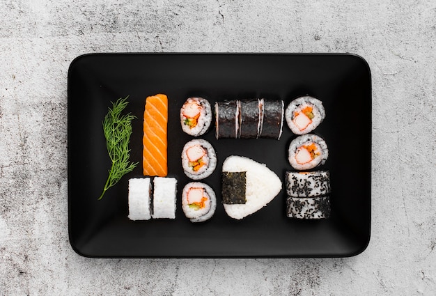 Assortment of sushi on black rectangular plate