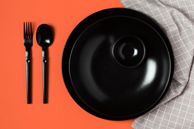 Assortment of tableware on orange background and cloth