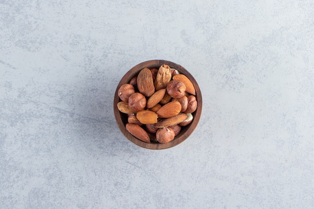 Assortment of tasty dried fruits and nuts in wooden bowl.