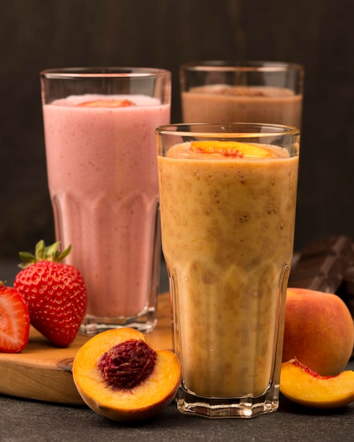 Assortment of three milkshake glasses with fruits and chocolate