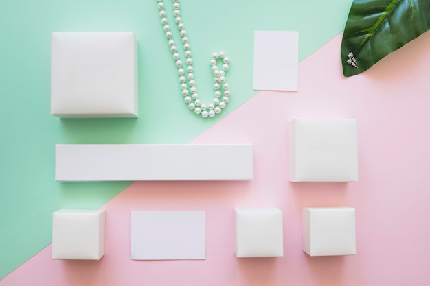 Assortment of white boxes, necklace and earrings with adhesive note on background