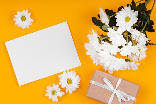 Assortment of white flowers with empty card and wrapped gift