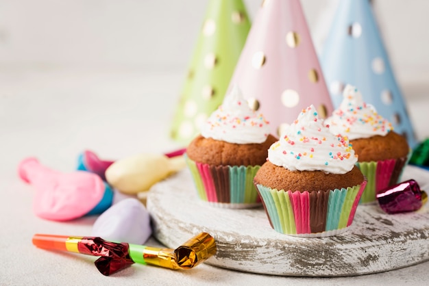 Foto gratuita assortimento con muffin glassati e decorazioni per feste