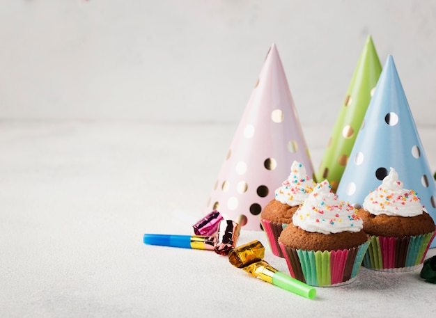 Assortment with glazed muffins and party hats