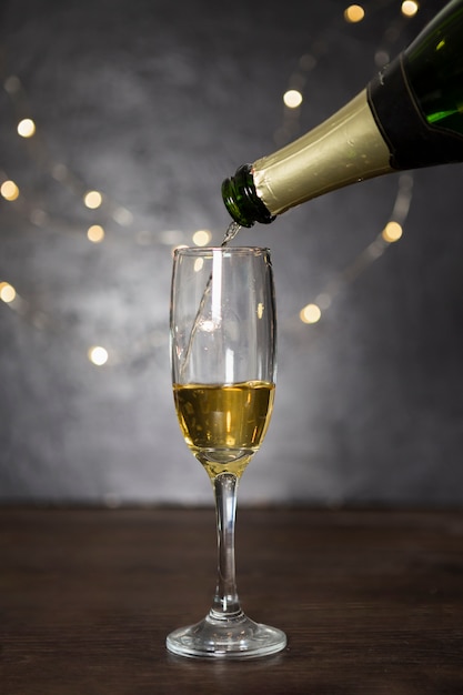 Foto gratuita assortimento con versando champagne e bicchiere