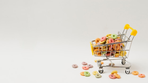 Assortment with shopping cart full of cereals