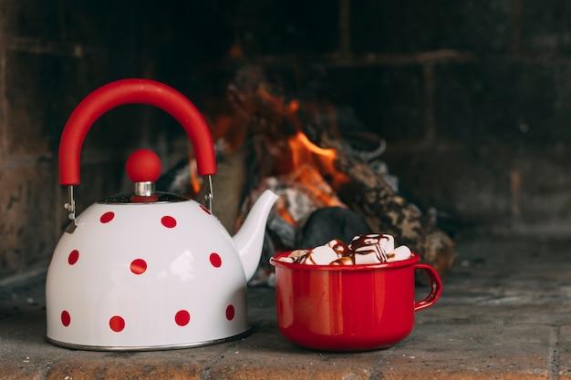 Assortment with teapot and mug near the fireplace