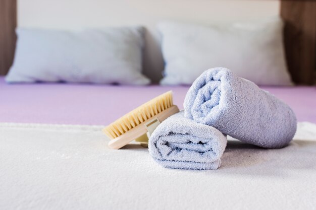 Assortment with towels and brush on bed 