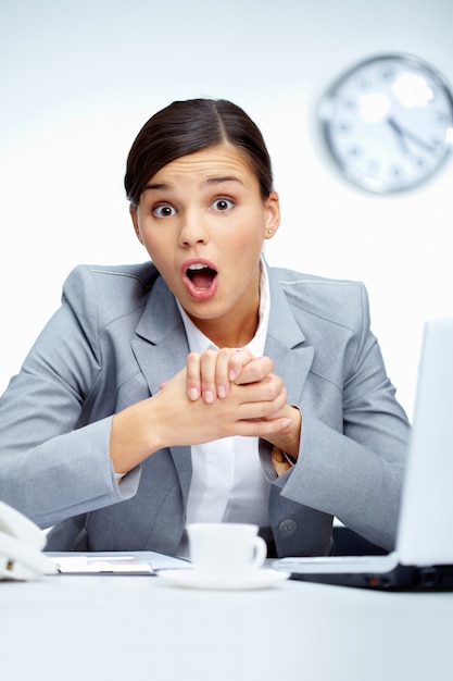 Free photo astonished executive sitting in her office