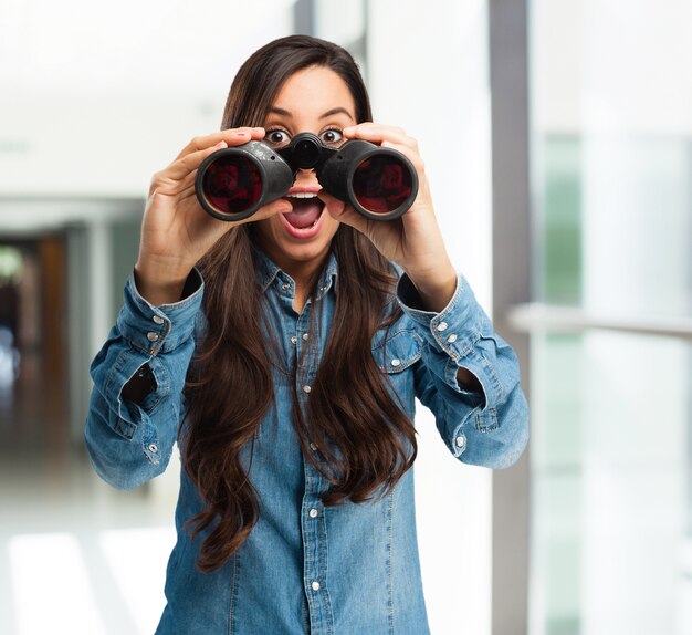 Astonished girl with binoculars