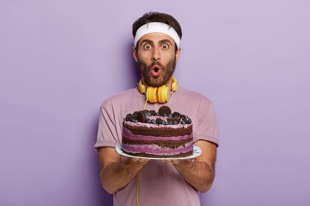 Astonished handsome guy with bristle, dark hair, stare at camera