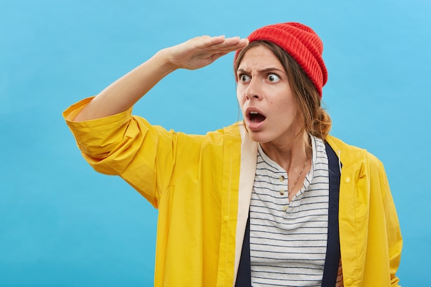 Astonished or puzzled stylish European girl looking into distance keeping mouth wide opened, holding hand at forehead, her look expressing complete shock and disbelief. Human facial expressions