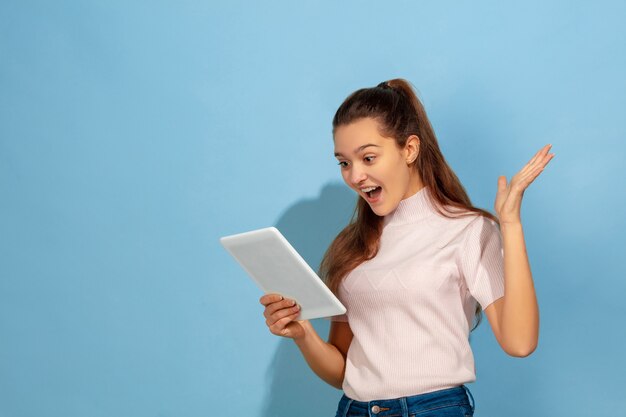 Astonished teenager girl using tablet