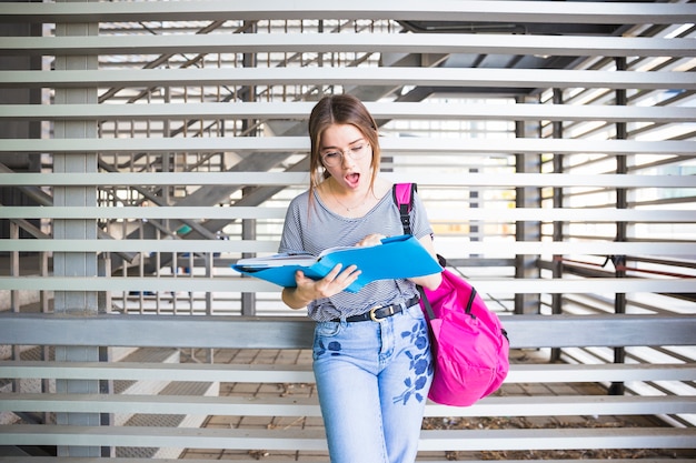 Astonished woman reading book