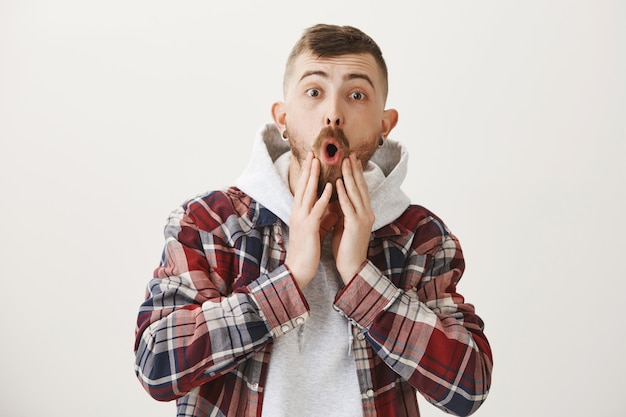 Free photo astounded and impressed hipster guy drop jaw and stare astonished