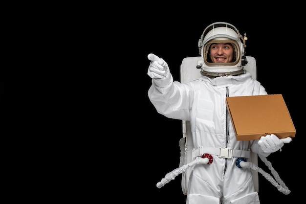 우주복을 입은 우주 비행사 날 우주 비행사는 우주 공간 우주 은하계에서 피자 상자를 들고 웃고 있습니다.
