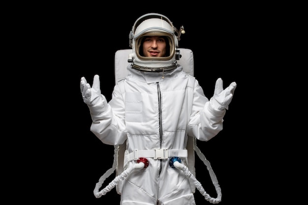 黒の背景の宇宙服の衣装の開いた手で隔離された宇宙飛行士の日の男宇宙飛行士