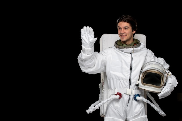 宇宙飛行士の日幸せな宇宙服を笑顔で言って手を振って銀河のヘルメットをかぶった宇宙飛行士