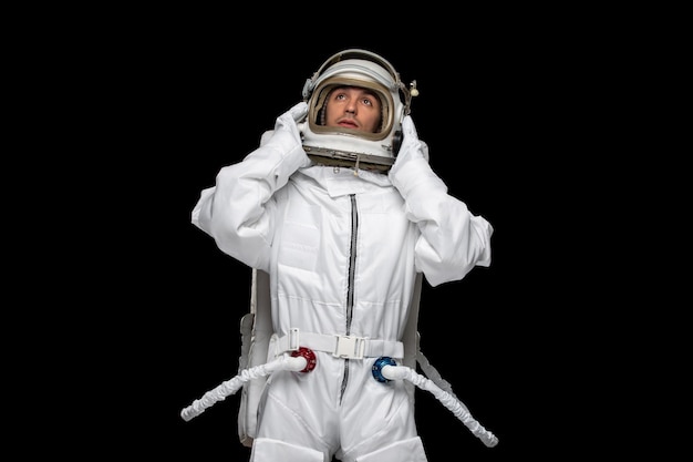 Foto gratuita astronauta astronauta in tuta spaziale galassia che tiene il casco guardando nel cosmo