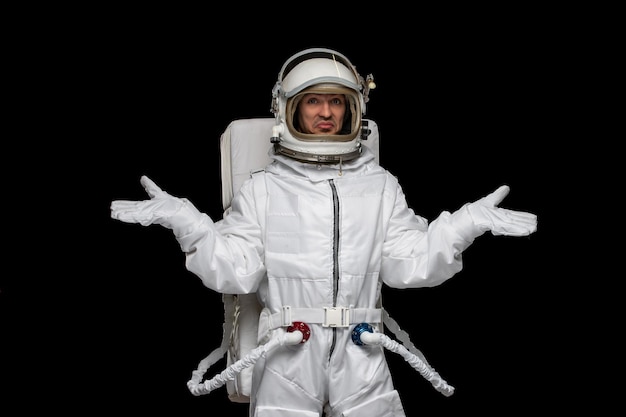 Бесплатное фото Космонавт дня космонавта в шлеме космического скафандра галактики машет руками в замешательстве космоса